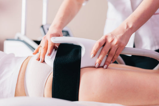 beauty therapist using body contouring machine on client