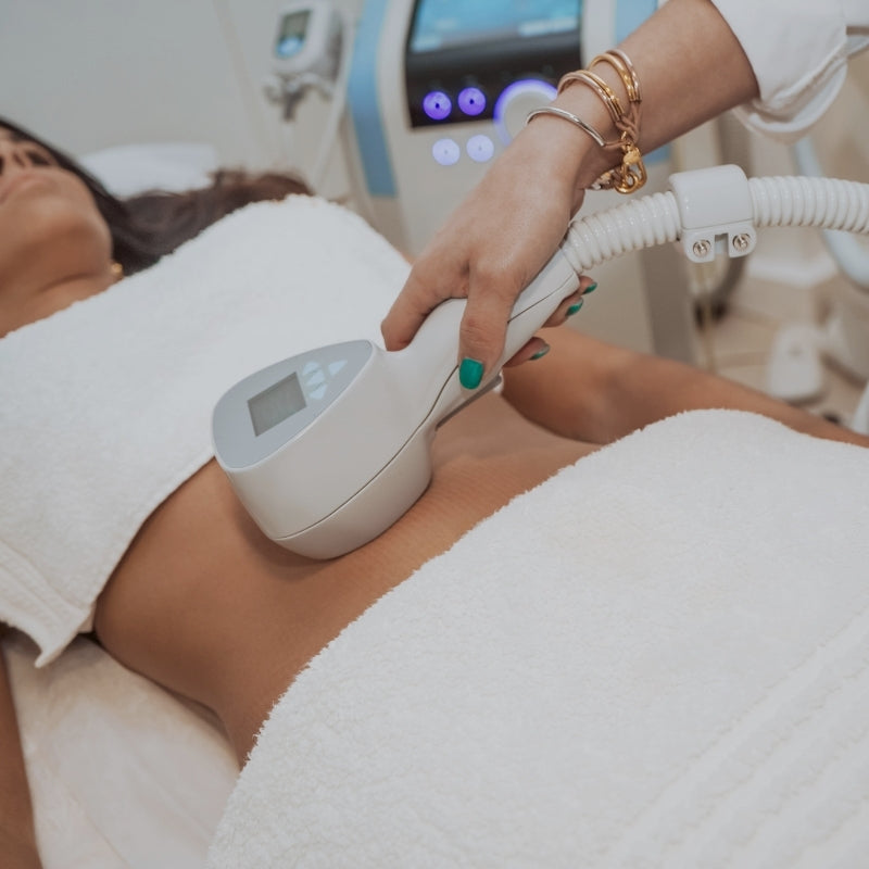 Person receiving a fat freezing treatment with device in clinic