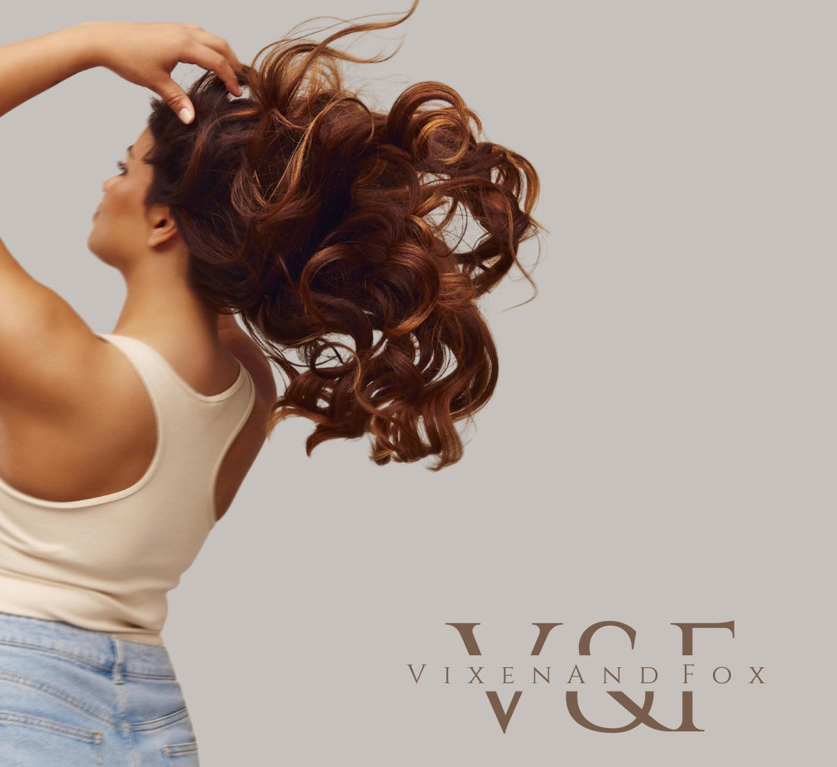 Woman with styled hair, wearing a white tank top and blue jeans, with 'Vixen and Fox' logo