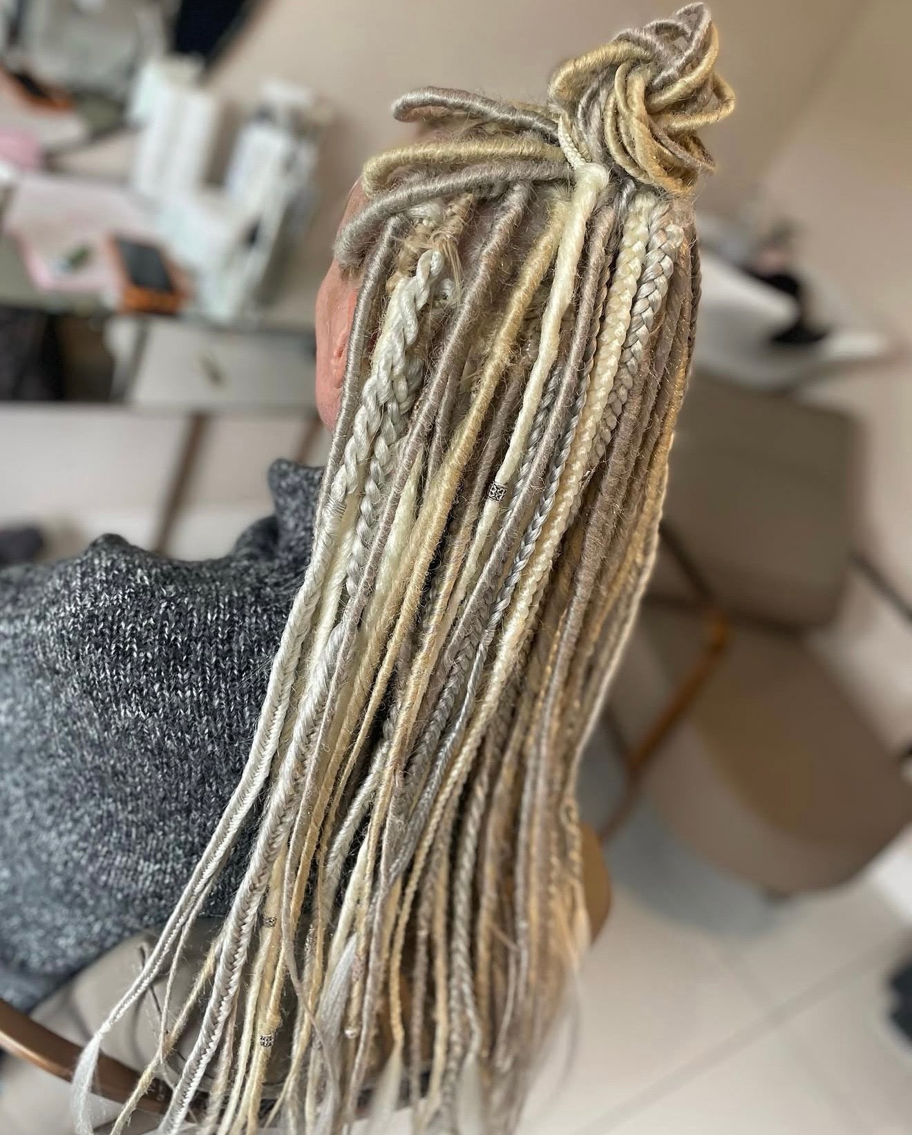 Braided hair extensions held by a person in a salon setting