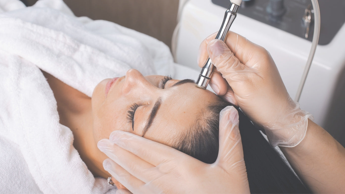 Person receiving a facial treatment with a device, wearing gloves.